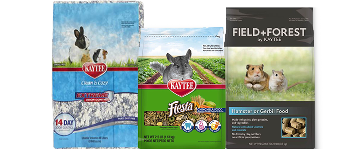 Three packages of Kaytee small pet products. From left to right: a blue and white bag of Kaytee Clean & Cozy Extreme Odor Control bedding with a rabbit on the front, a green bag of Kaytee Fiesta Chinchilla Food with a chinchilla on the front, and a black package of Field+Forest by Kaytee Hamster or Gerbil Food with two hamsters on the front.